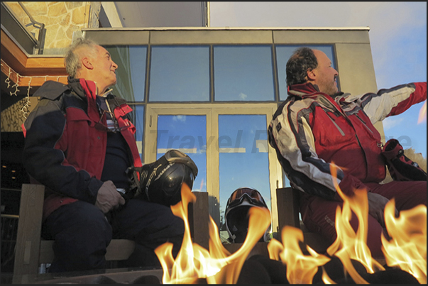 Two chats around the fire after a day of skiing to observe the alpine circle at sunset