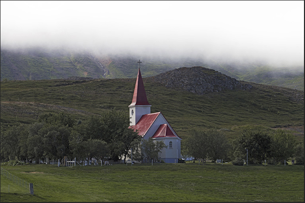 Along the Eyjafjordur Fjord, there are small countries like Holl with his church that stands out among the green fields