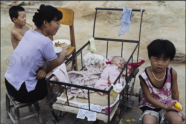 Mongin Village. As men work in the fields, women care for children Mongin Village. As men work in the fields, women care for children