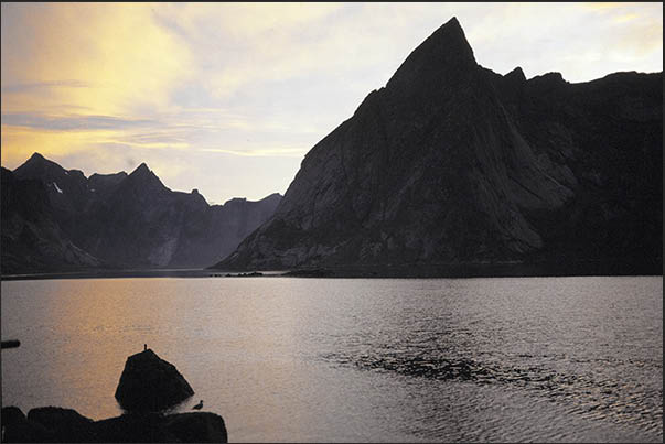Sunset between the rocky peaks of the mountains of Moskenosoya island (Lofoten) Sunset between the rocky peaks of the mountains of Moskenosoya island (Lofoten)