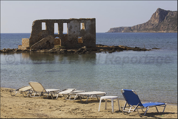 The beach of Plytra with the ruins of an ancient house of the Venetian era The beach of Plytra with the ruins of an ancient house of the Venetian era